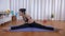 Sporty Indian girl doing sitting toe touch on a yoga mat - home workout concept