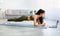 Sporty Indian woman standing in elbow plank, following video tutorial on laptop at home