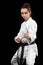 Sporty karate and taekwondo woman in white kimono with black belt on dark background. Sport concept with copy space.