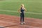 Sporty Lifestyle. Young woman wearing digital watch on stadium standing on track hands on hips smiling joyful