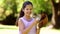 Sporty little girl smiling at camera in the park playing with baseball