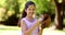 Sporty little girl smiling at camera in the park playing with baseball