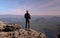 Sporty man on mountain peak looking on mountain valley