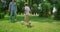 Sporty man passing ball to active son on green park. Father play soccer with boy