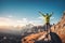 Sporty man standing on the stone with raised up arms