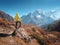 Sporty man on the stone is looking on snow covered mountains