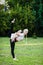 Sporty mother and daughter stretching on grass