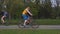 Sporty people ride bicycles along special road in park