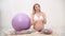 A sporty pregnant young woman blogger talks about ball exercises.