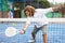 Sporty resolved man playing padel on open court