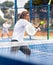 Sporty resolved man playing padel on open court