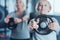 Sporty retired lady holding weight disk at fitness club