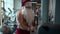 Sporty santa claus doing rope extension at gym. Fit man training in sport club