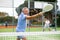 Sporty senior man playing padel on open tennis court