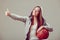 Sporty teen girl in hood holding basketball.