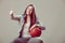 Sporty teen girl in hood holding basketball.