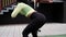 sporty woman in black and green sportswear doing sport exercises outside on sport playground. perfect healthy slim body.