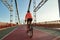 Sporty woman in helmet cycle on bridge