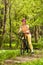 Sporty woman with mountain bike on woodland trail