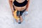 Sporty woman with a perfect body measuring body weight on electronic scales and holding a yellow banana and a bottle of