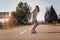 Sporty woman riding on the skateboard on the road