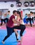 Sporty woman with trainer are doing self-defence moves in gym