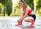 Sporty woman tying laces on sneakers in park