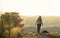 Sporty woman walking at the mountain top against foggy landscape and cityscape of Murcia in Spain. Adventurer hiking in