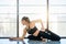 Sporty yoga girl in pigeon pose. Woman in black sportswear doing stretching.