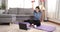 Sporty young asian woman doing exercising with dumbbells and watching fitness video tutorial online