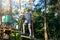 Sporty, young, cute boy in white t shirt spends his time in adventure rope park in helmet and safe equipment in the park