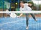 Sporty young girl playing padel on open court