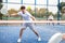 Sporty young guy playing padel on open court