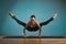 Sporty young woman doing stretching. Slim girl practicing yoga indoors on blue background. Calm, relax, healthy