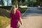 Sporty young woman in headphones holding longboard