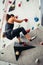 Sporty young woman training in a colorful climbing gym. Free climber girl climbing up indoor