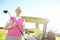 Spot of golf. Low angle shot of an attractive older female golfer standing in front of a golf cart with her golfing