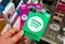 Spotify green gift cardof premium subscription in a hand at store over gift cards