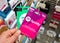 Spotify pink gift card of premium subscription in a hand at store over gift cards