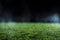 Spotlight shining on the green turf of an empty sports field at night