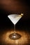 Spotlight on a single chilled martini, with olives, shot on a da