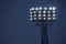 Spotlights illuminate football field while match. Lighting equipment for stadium