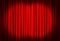 Spotlights illuminating closed red stage curtains. Start of performance