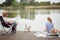 Spouses enjoy fishing and a picnic with their dog