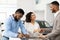 Spouses Shaking Hands With Auto Seller Signing Papers In Dealership