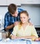 Spouses signing documents and smiling at kitchen