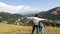 spouses, tourists stop on a high mountain, arms wide open, look with admiration at the resort town of Jermuk