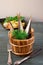 Sprats in wooden barrels with greens on a background of potatoes