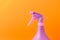 Spray nozzle on a bottle/purple spray nozzle on a bottle on a orange background. Copy space