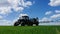 Spraying a green wheat field by tractor.